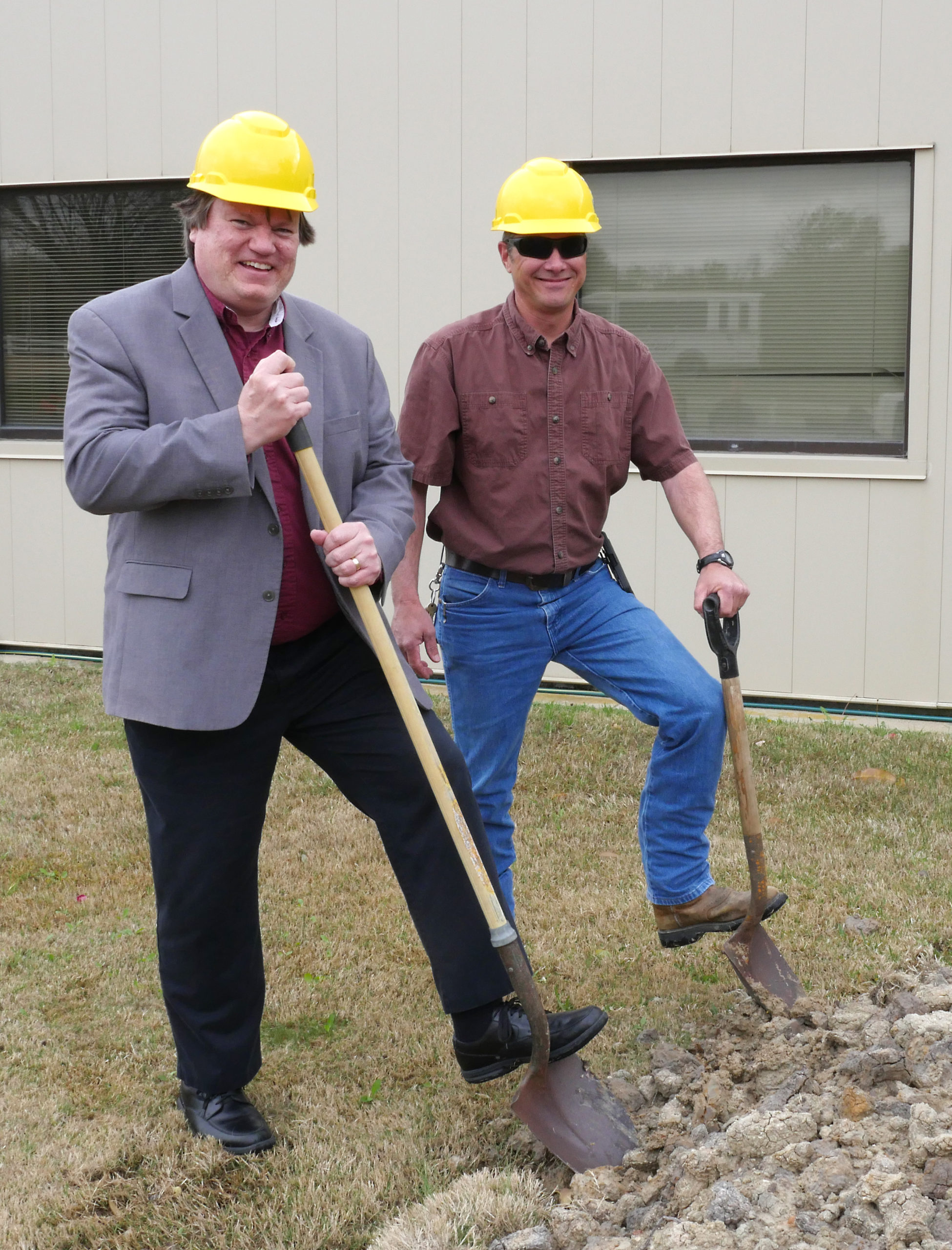Dr. Eric Petersen and Carl Johnson with hard hats and shovels at the construction site of the new turbo lab office. 